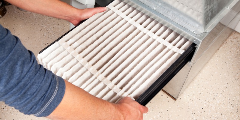 Persons hands changing furnace filter