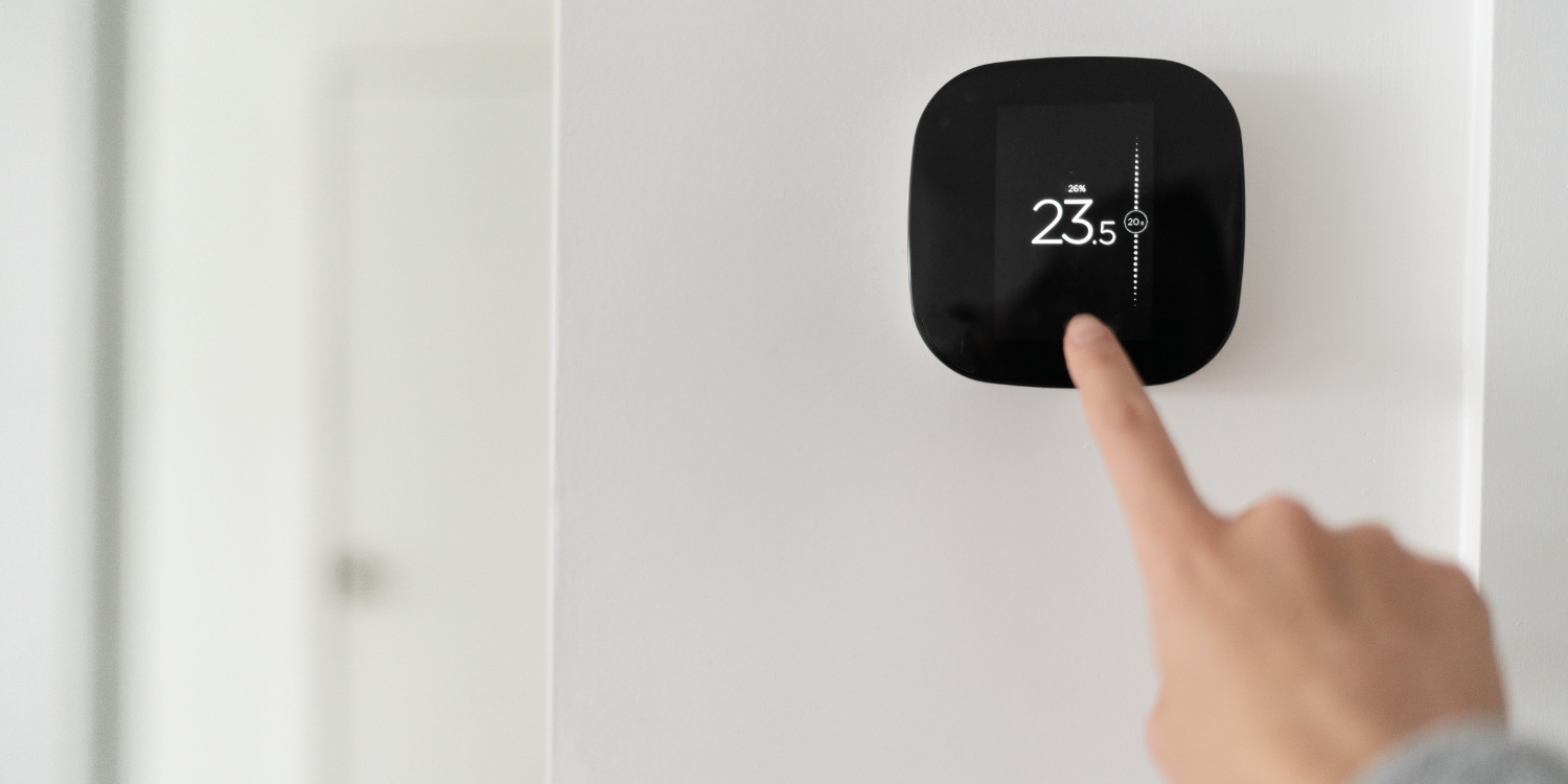 Person changing temp on Smart Thermostat - Ontario HVAC Rebates - Your Ultimate Guide for 2024